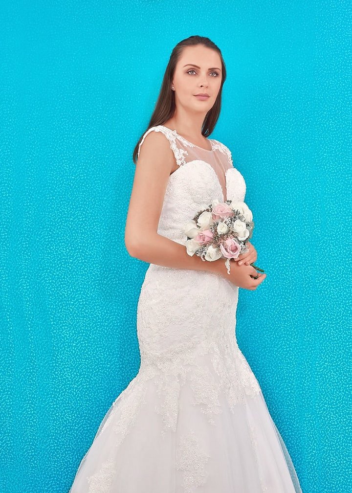 Este diseño de vestido de novia en corte sirena destaca a la mujer extravagante que quiere capturar la atención. El audaz escote corazón. Brinda un delicado efecto de brillo gracias a los cristales bordados
