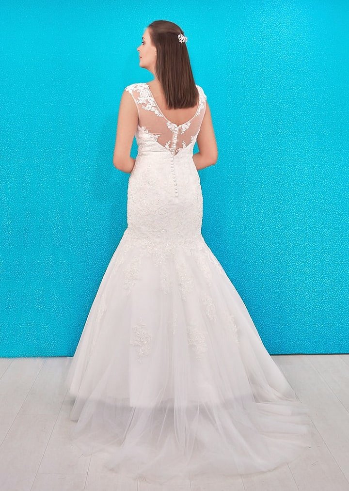Este diseño de vestido de novia en corte sirena destaca a la mujer extravagante que quiere capturar la atención. El audaz escote corazón. Brinda un delicado efecto de brillo gracias a los cristales bordados
